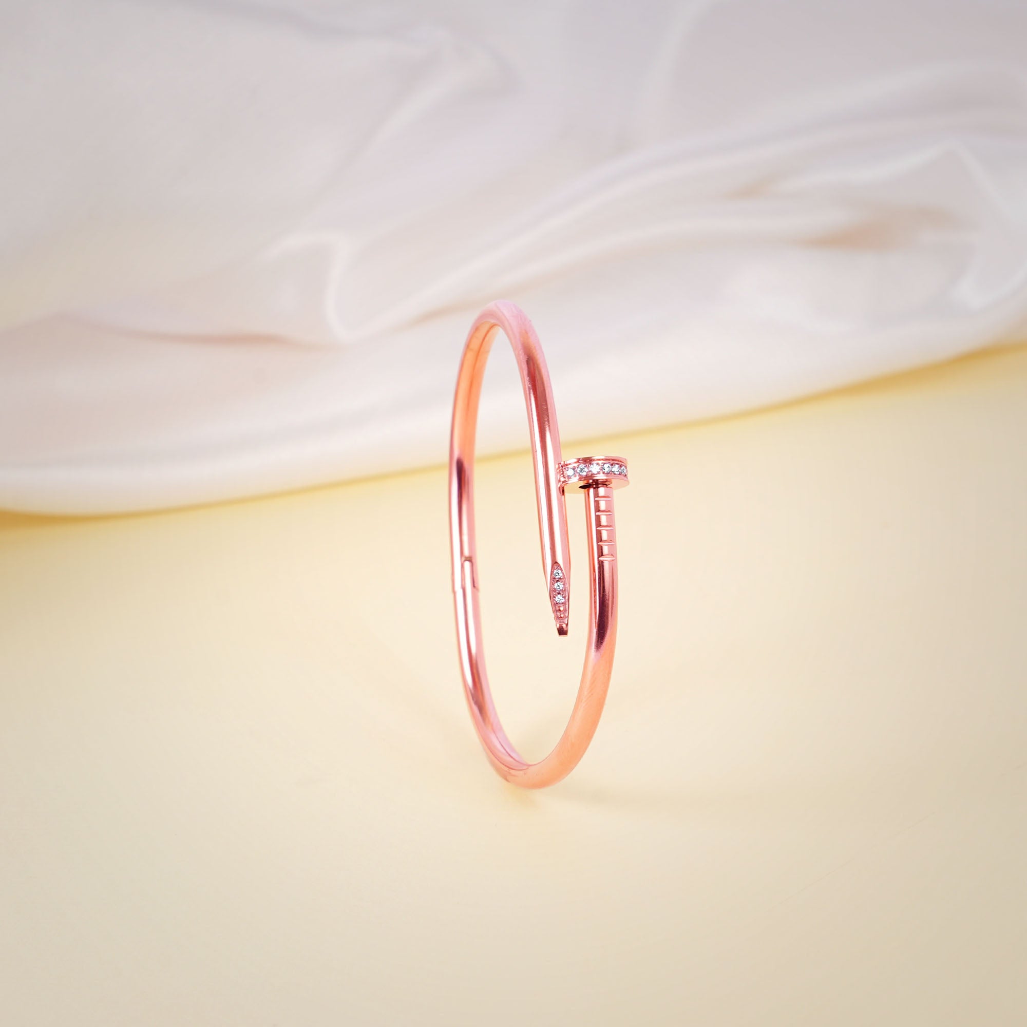 Rose gold bracelet on a soft fabric background