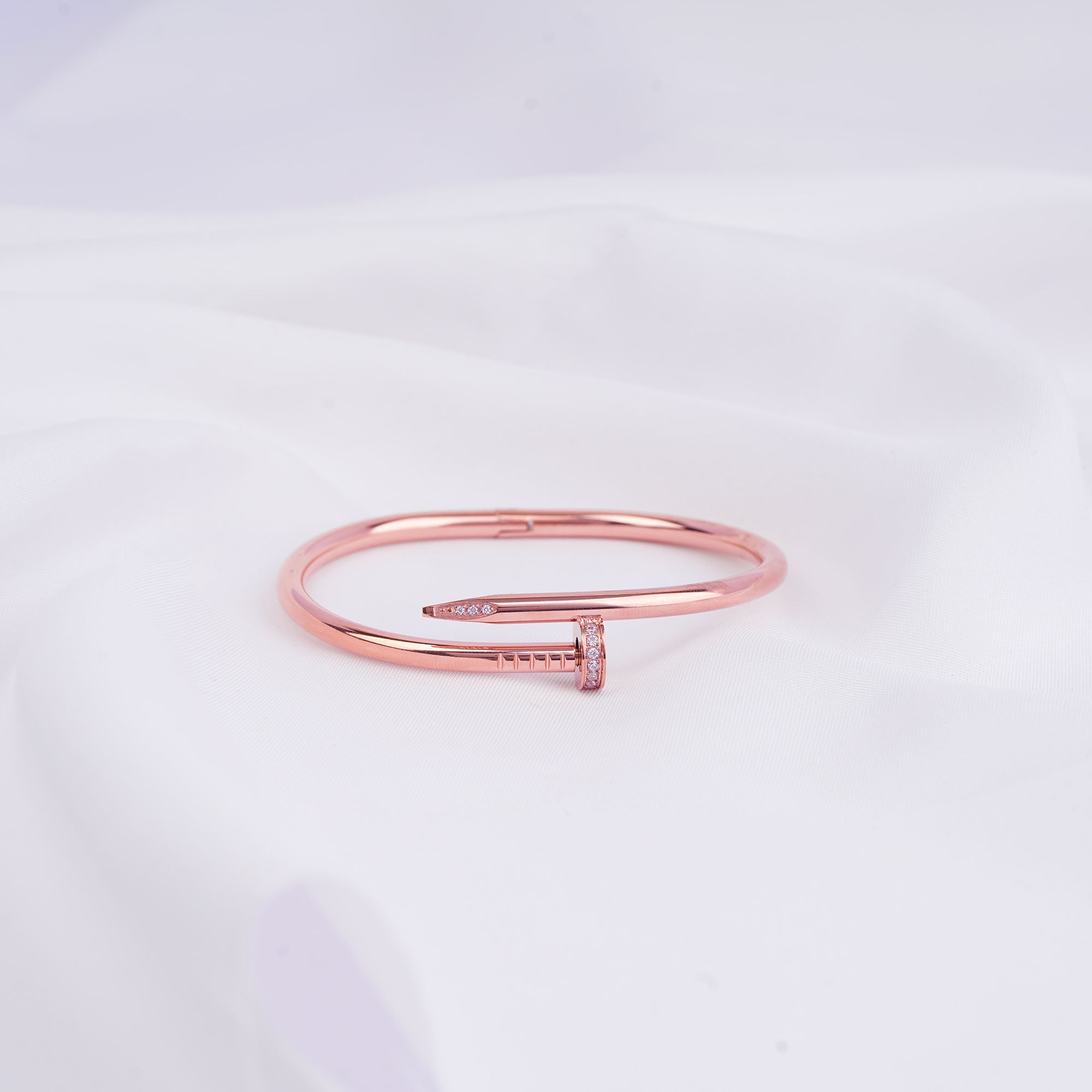 Rose gold bracelet on a light gray background