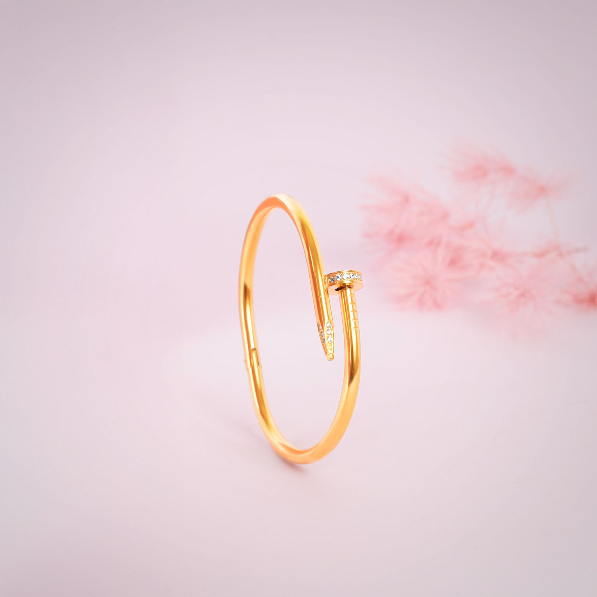 Gold bracelet on a light pink background