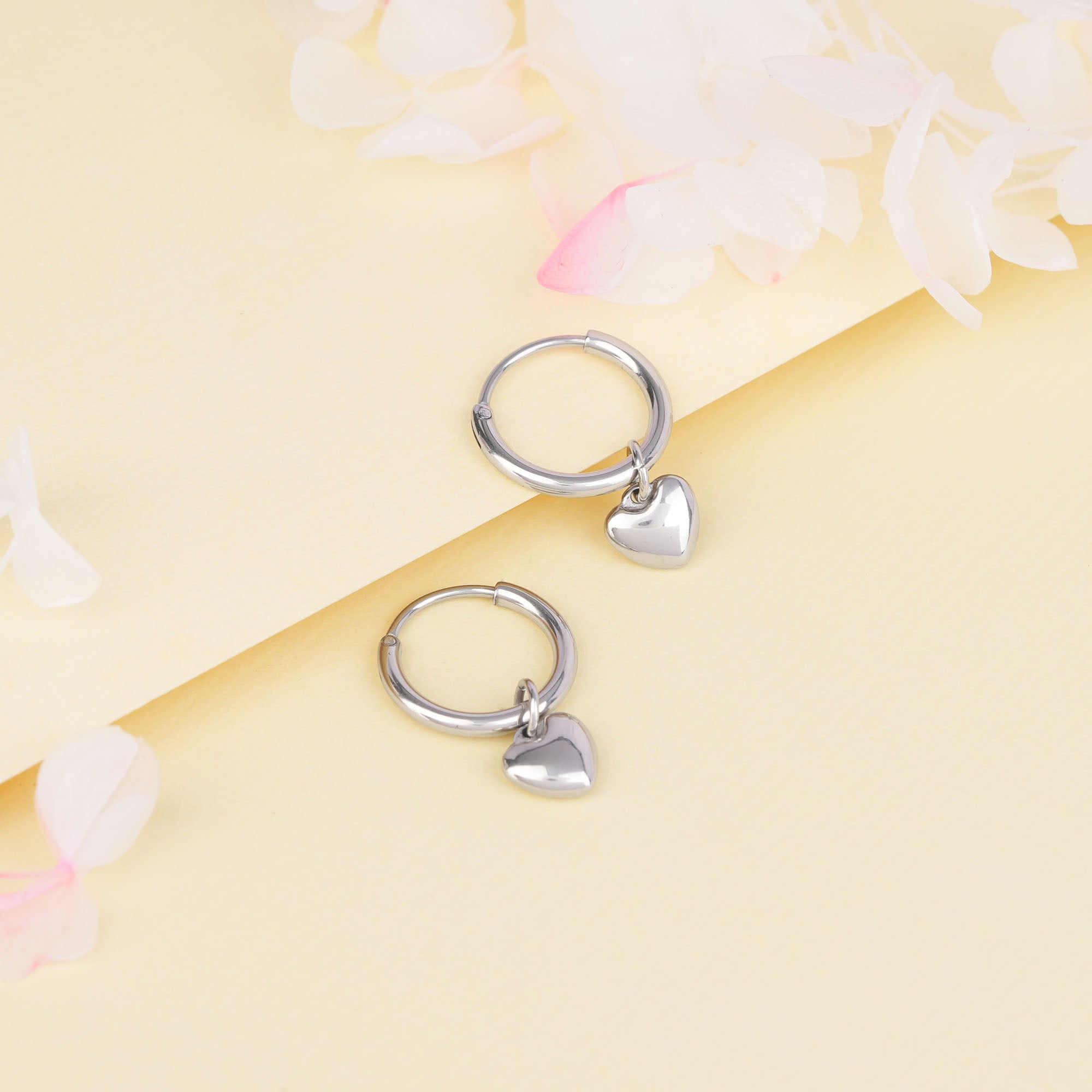 Small silver hoops with dangling hearts