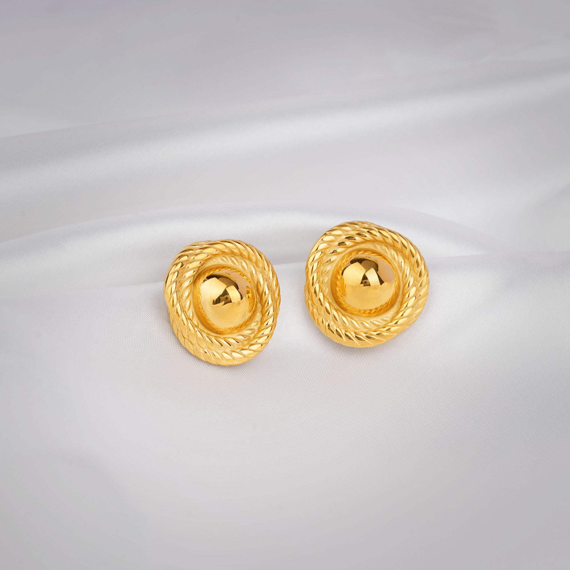 Pair of gold earrings on a light gray background