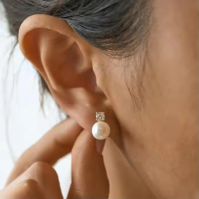 Pearl earring worn on an ear with a blurred background