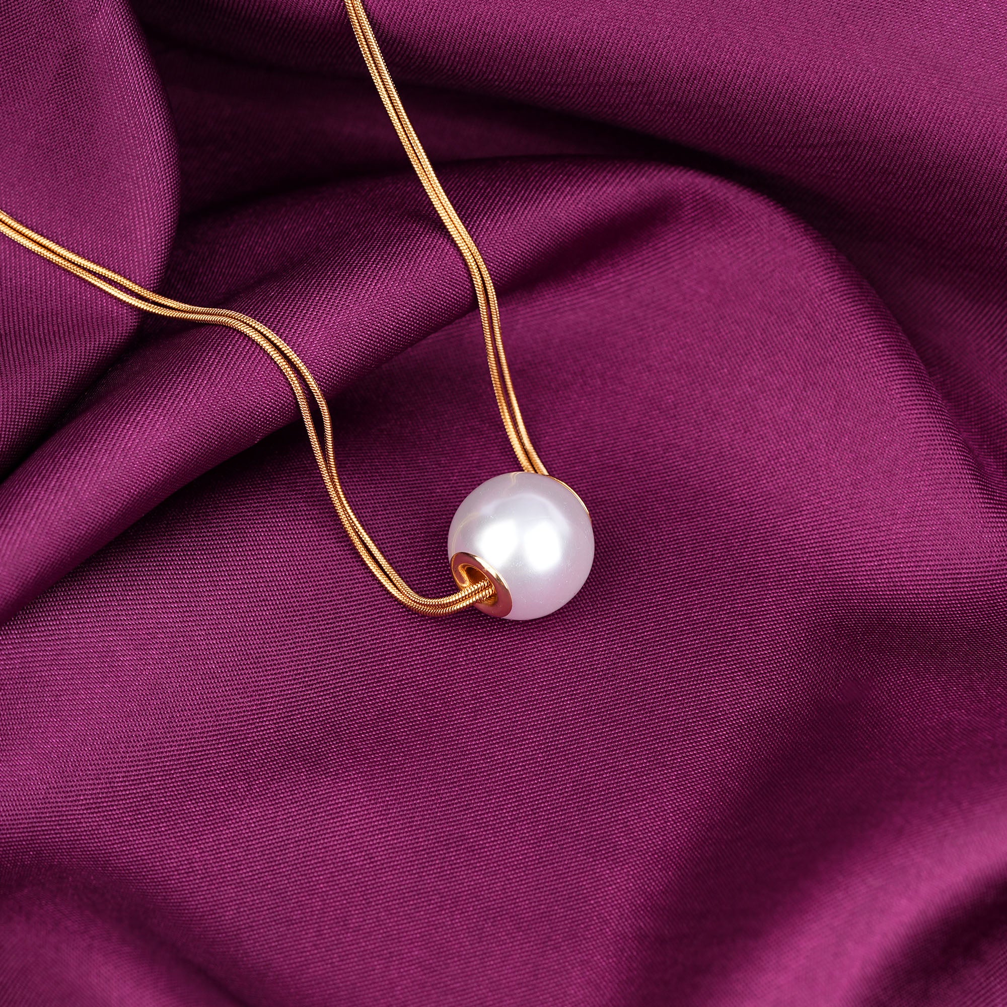 Pearl necklace on a purple fabric background