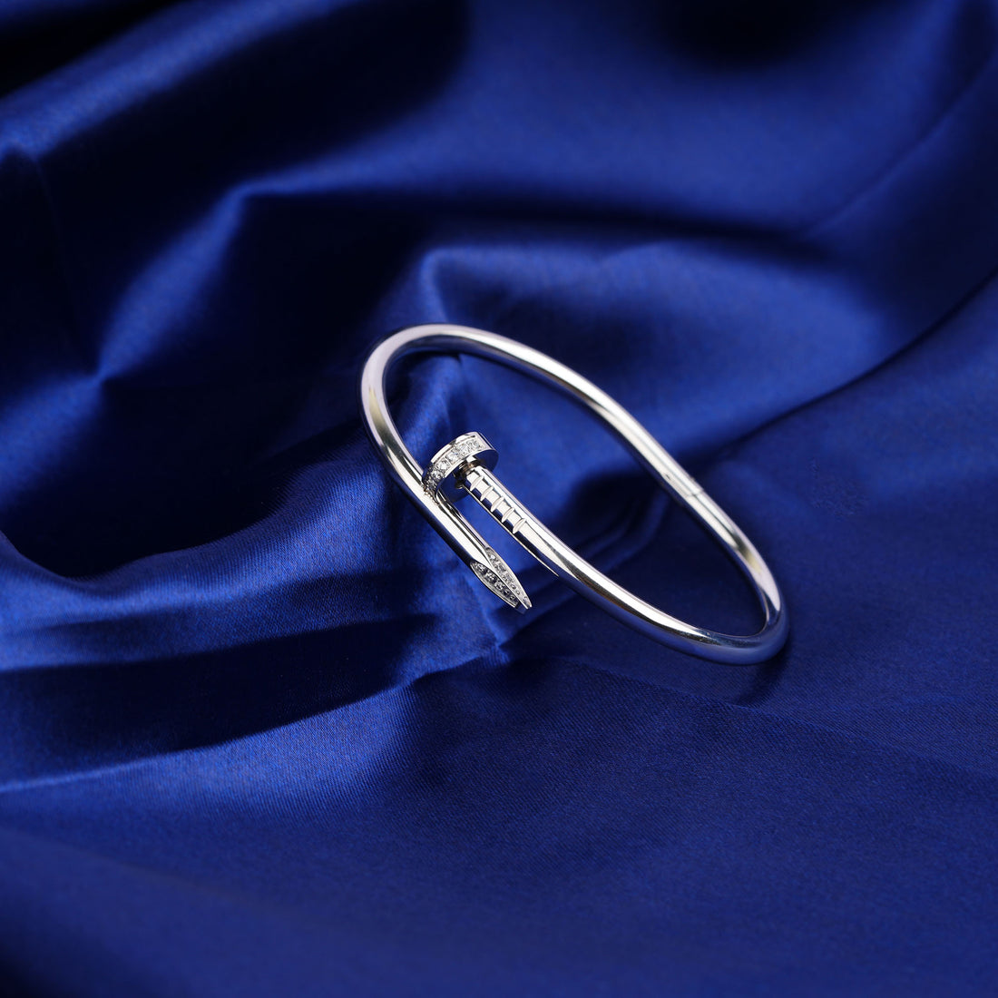 Silver bracelet on a blue satin background