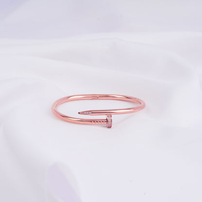 Rose gold bracelet on a light gray background