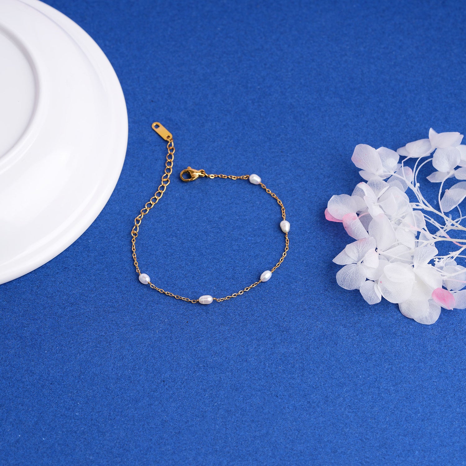 Gold bracelet with pearls on a blue background
