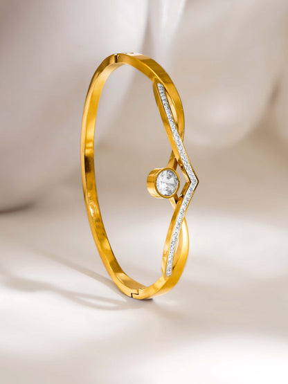 Gold bracelet with a diamond on a light beige background