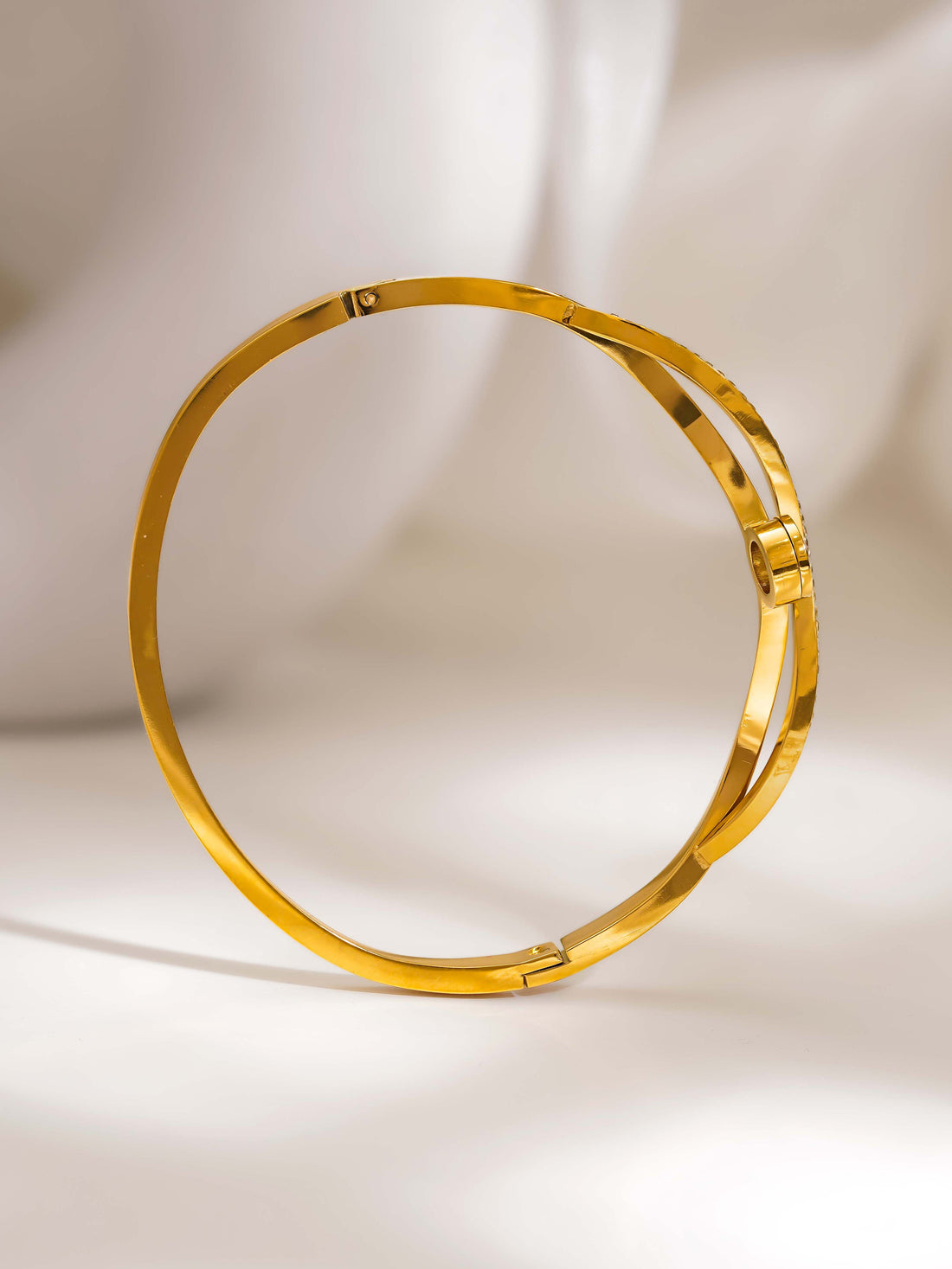 Gold bracelet on a light beige background