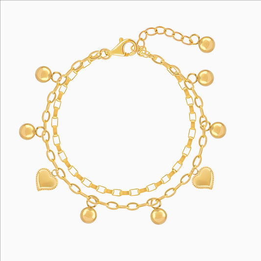 Gold bracelet with heart and round charms on a white background