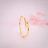 Gold bracelet on a light pink background