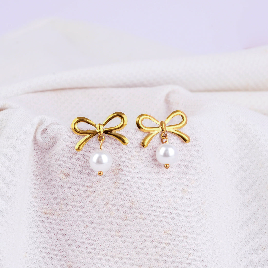 Gold hoop earrings with bow and white pearl