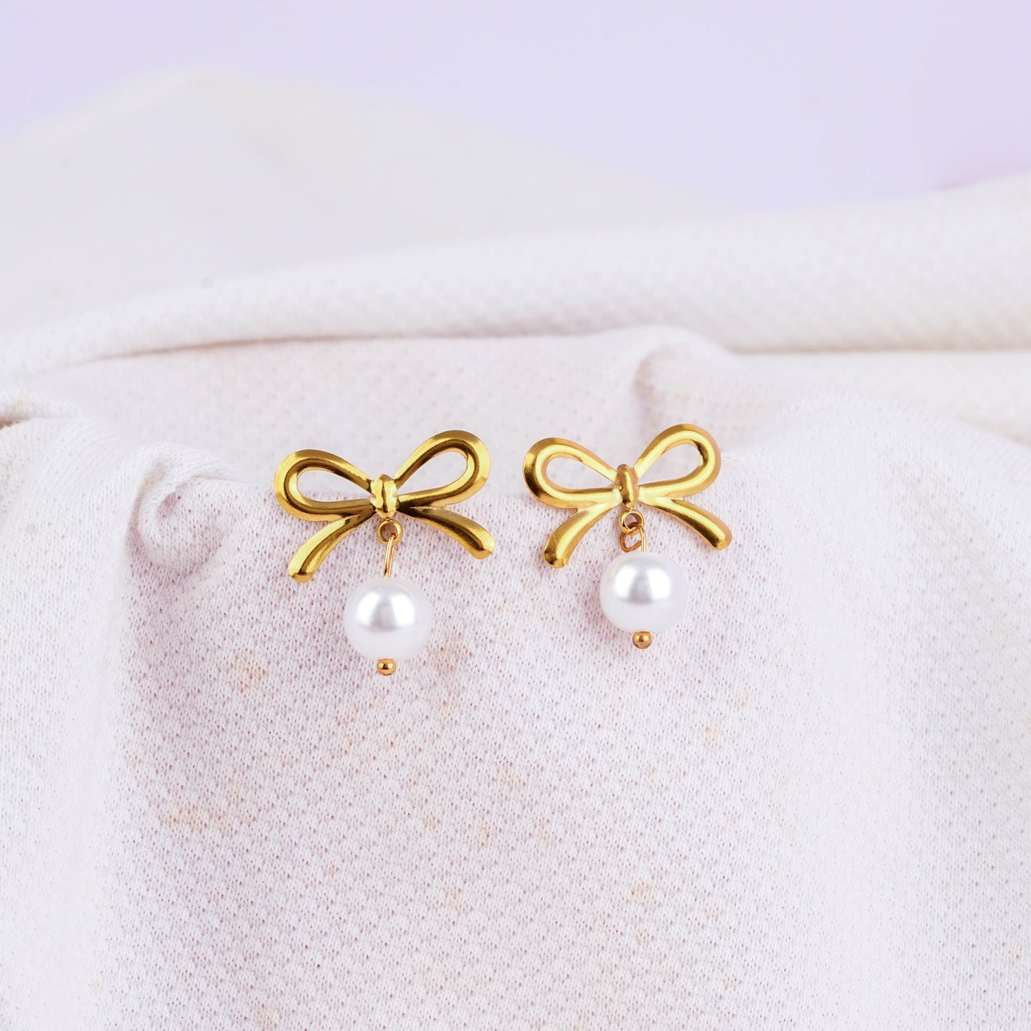 Gold hoop earrings with bow and white pearl