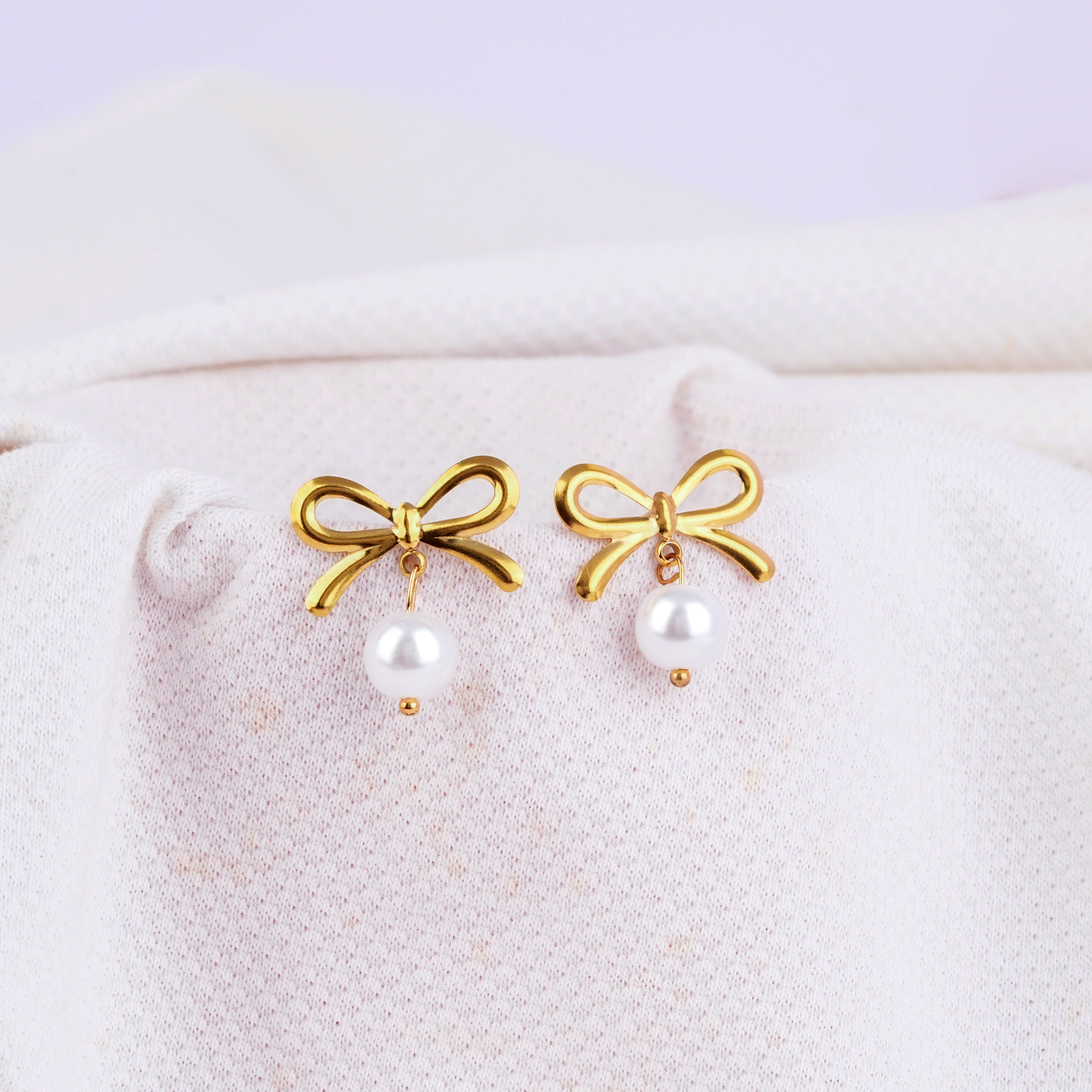 Gold hoop earrings with bow and white pearl