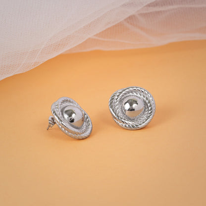 Pair of silver earrings on a beige background