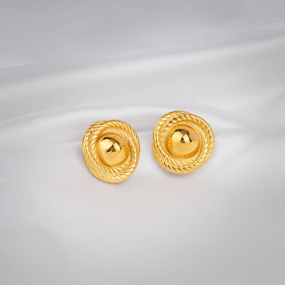 Pair of gold earrings on a light gray background