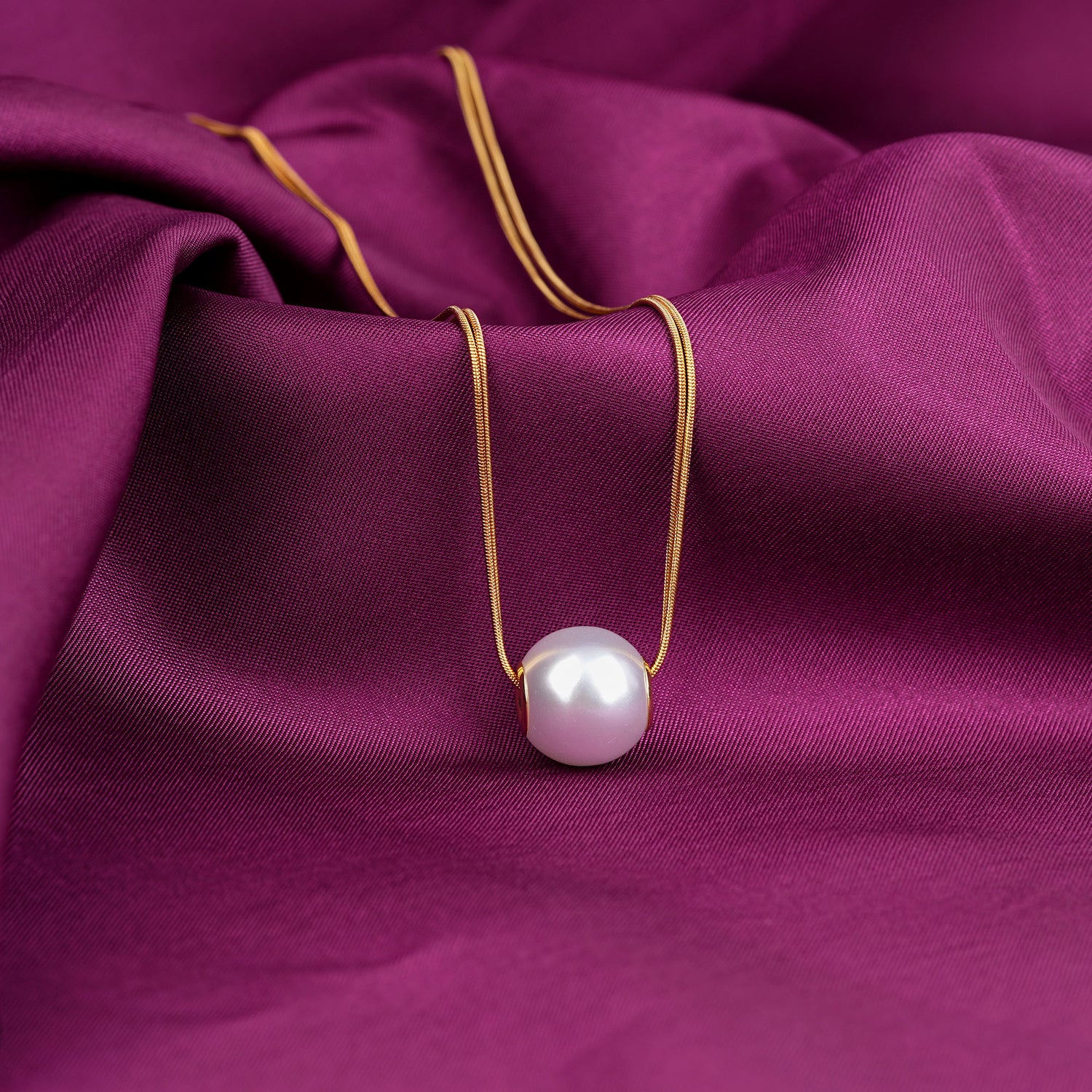Pearl necklace on a purple fabric background
