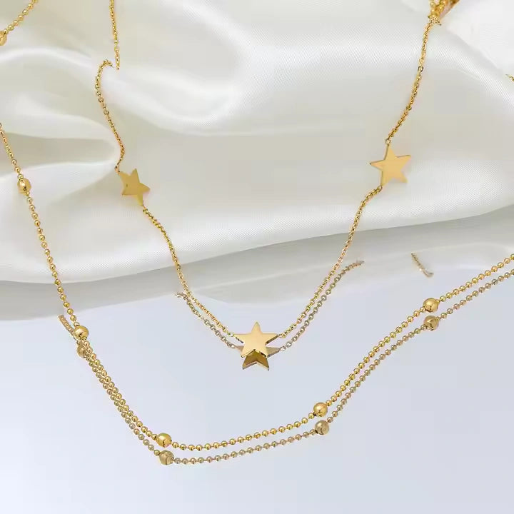 Gold star necklace on a white satin background