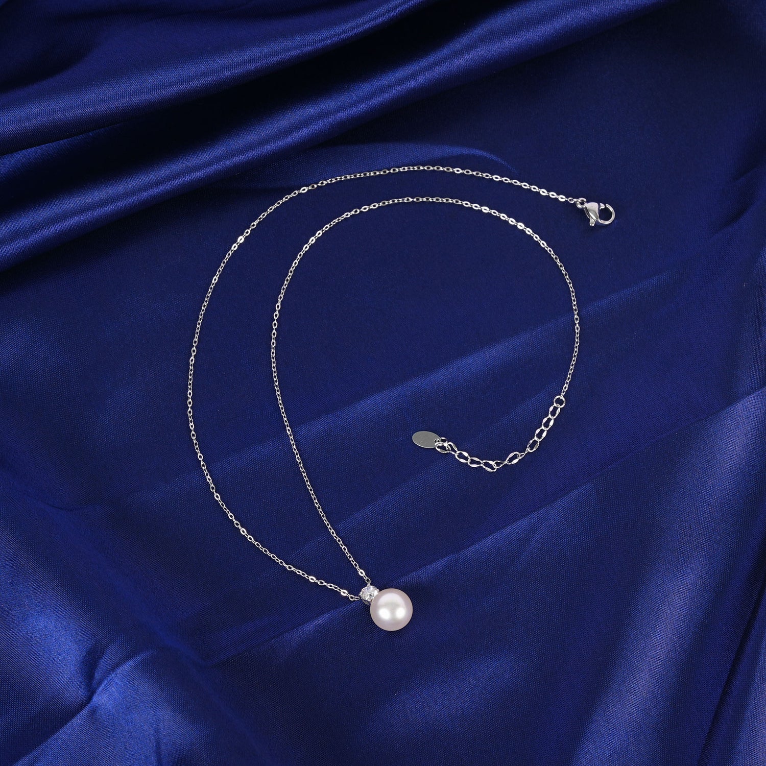 Pearl necklace on a blue satin background
