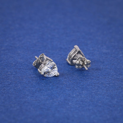 Pair of silver heart-shaped gemstone stud earrings on a blue background