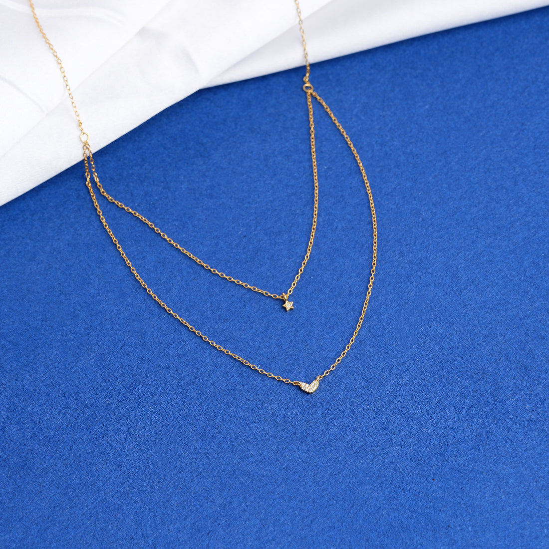 Gold necklace on a blue and white background