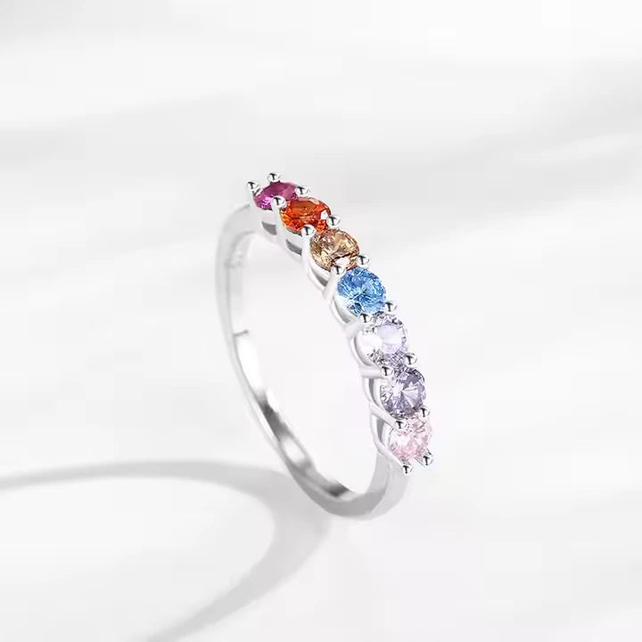 Silver ring with multicolored gemstones on a white background