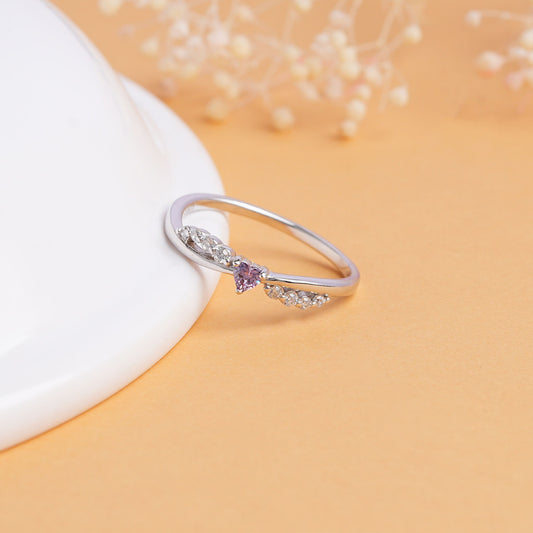 Silver ring with a purple gemstone on a beige background